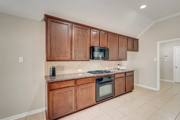 a kitchen with granite countertop cabinets stainless steel appliances and a counter space