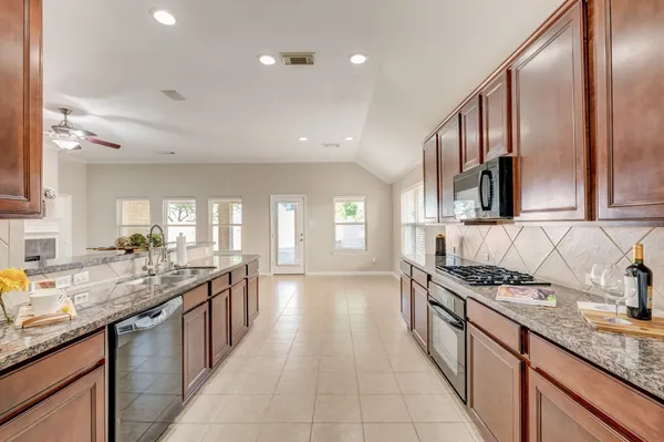 a kitchen with granite countertop a sink and white cabinets