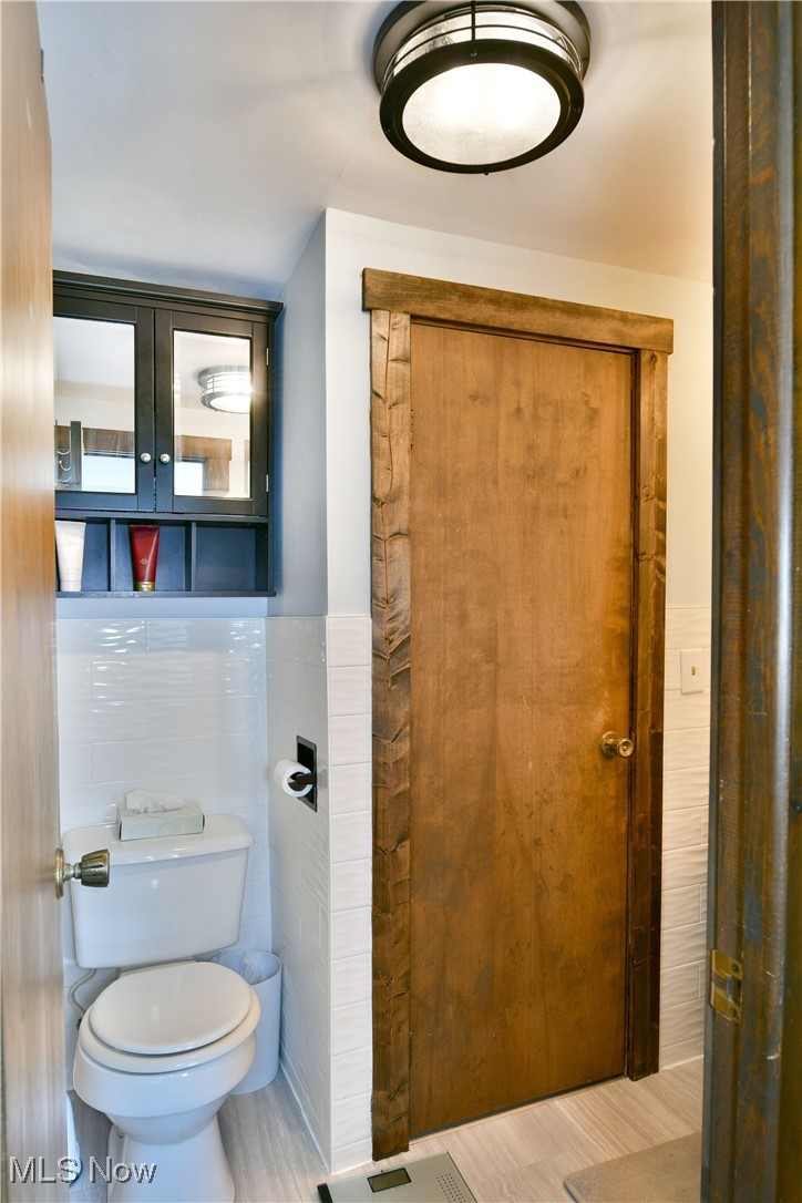 1509 State Road Northwest Warren, OH 44481 - Photo 31 of 49 Bathroom featuring toilet, hardwood / wood-style flooring, and tile walls