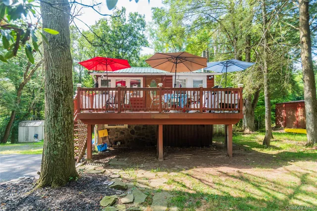 a view of a house with a yard deck and a patio