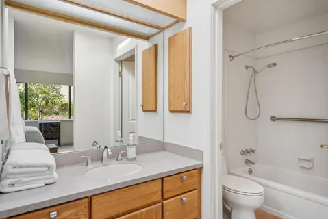 a bathroom with a granite countertop sink toilet and shower