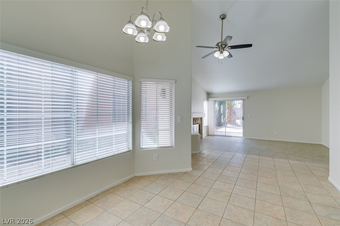 307 Cavalla Street Henderson, NV 89074 - Photo 19 of 44 Vast tile flooring connects the dining area to a spacious living room with vaulted ceilings and patio access.