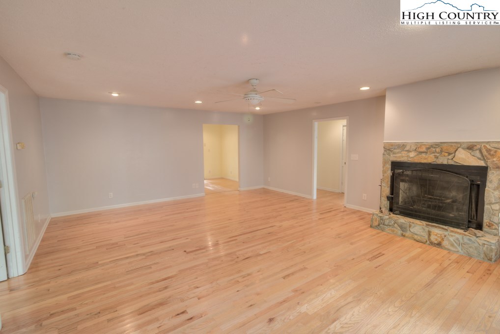 305 Signal Tree Road Deep Gap, NC 28618 - Photo 6 of 33 a view of an empty room with wooden floor fireplace and a window