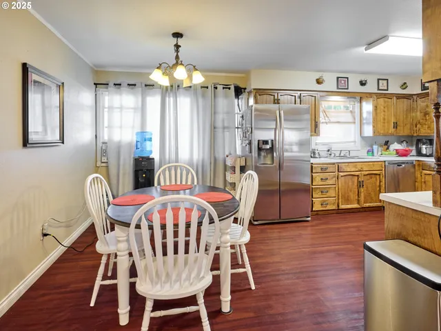 a view of a dining room with furniture a chandelier and wooden floor