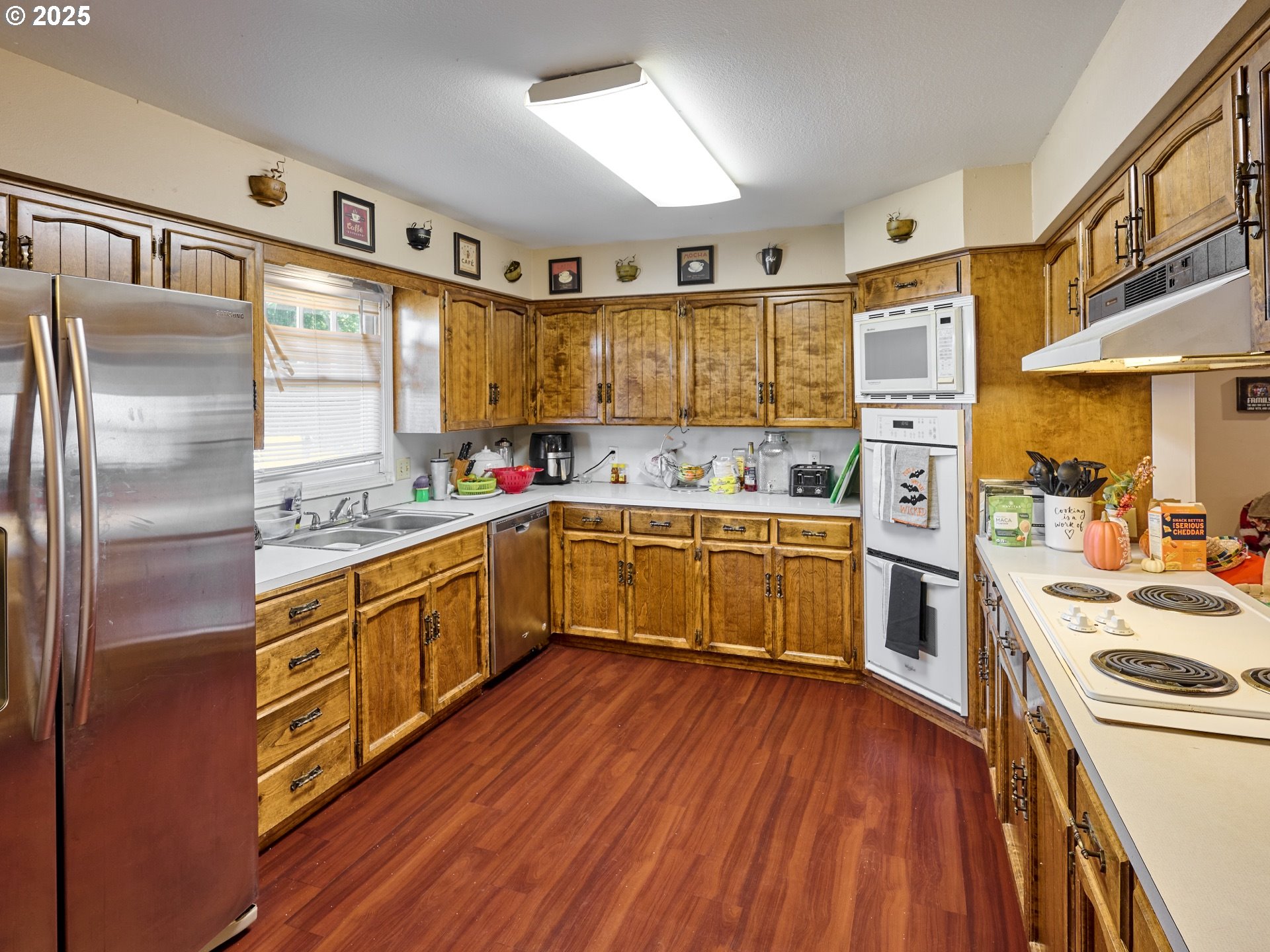 4481 Hennies Road Southeast Turner, OR 97392 - Photo 4 of 47 a kitchen with stainless steel appliances a stove a sink dishwasher a refrigerator white cabinets and wooden floor