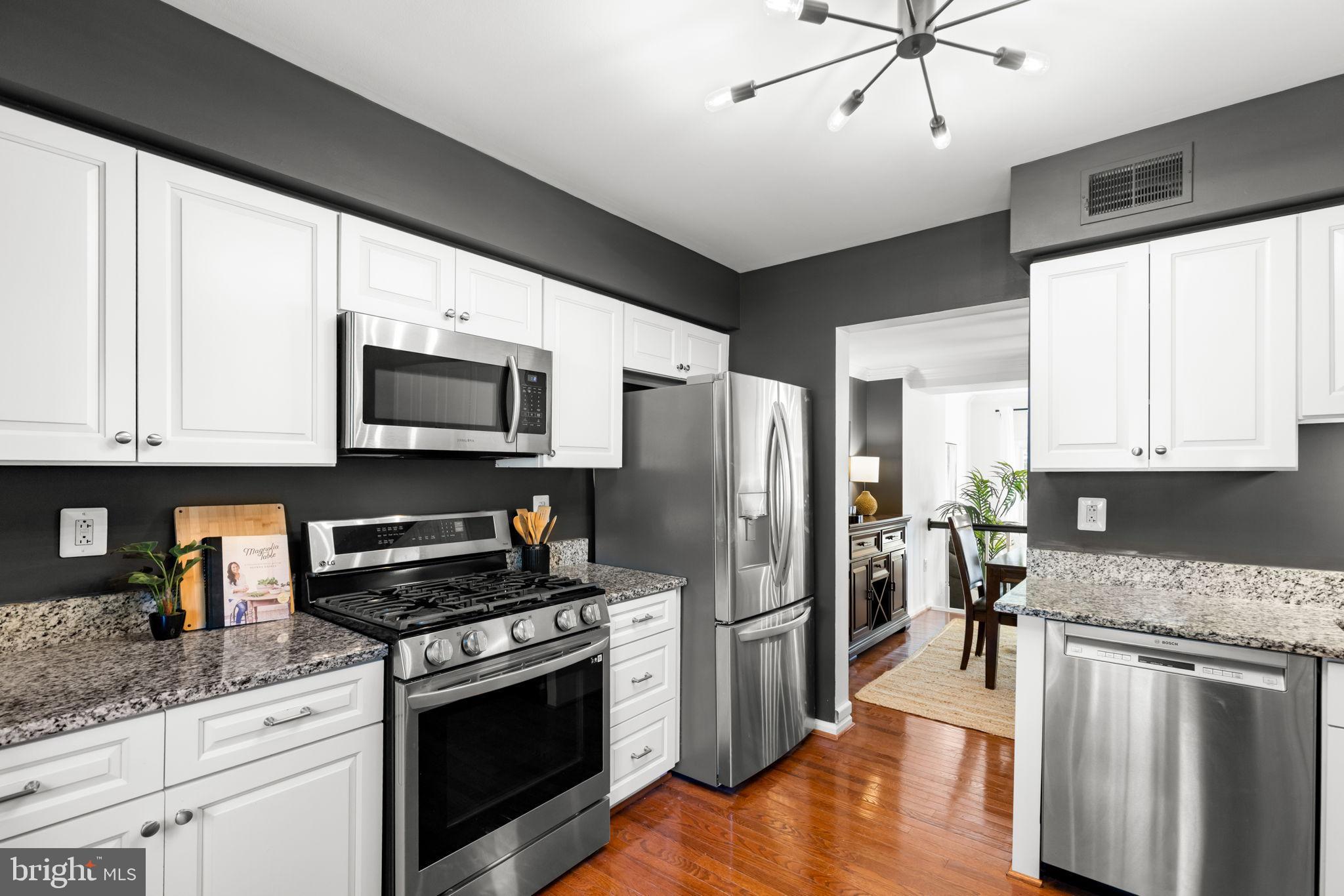 6223 Walkers Croft Way Alexandria, VA 22315 - Photo 10 of 38 a kitchen with stainless steel appliances granite countertop a stove a refrigerator a sink a oven with white cabinets and wooden floor
