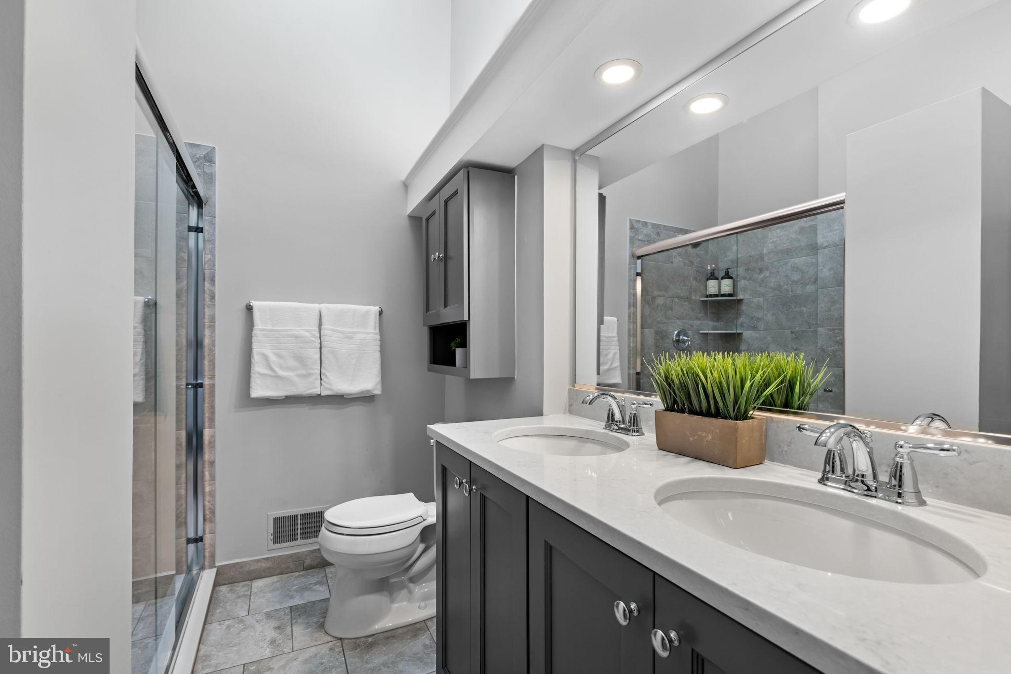 6223 Walkers Croft Way Alexandria, VA 22315 - Photo 23 of 38 a bathroom with a granite countertop sink toilet a large mirror and shower