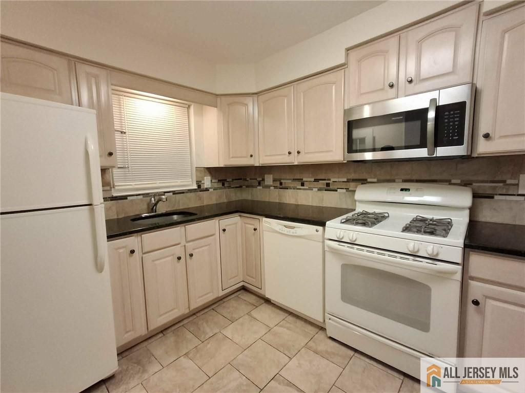 363 Cranbury Road, Unit A3 East Brunswick, NJ 08816 - Photo 16 of 16 a kitchen with granite countertop white cabinets sink and stainless steel appliances