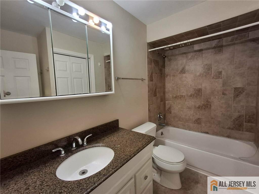 363 Cranbury Road, Unit A3 East Brunswick, NJ 08816 - Photo 4 of 16 a bathroom with a granite countertop sink toilet a mirror and shower