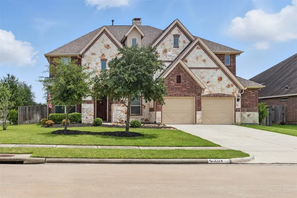 a front view of a house with a yard and trees