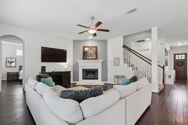a living room with furniture kitchen view and a large window