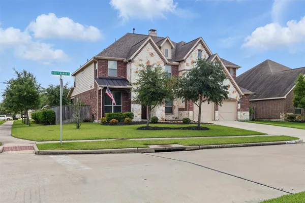 a front view of a house with a yard and trees