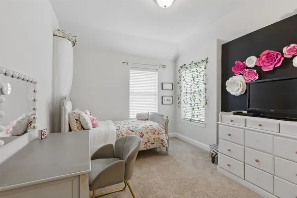 a bedroom with a bed dresser and mirror
