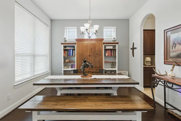a view of dining room and kitchen island with wooden floor