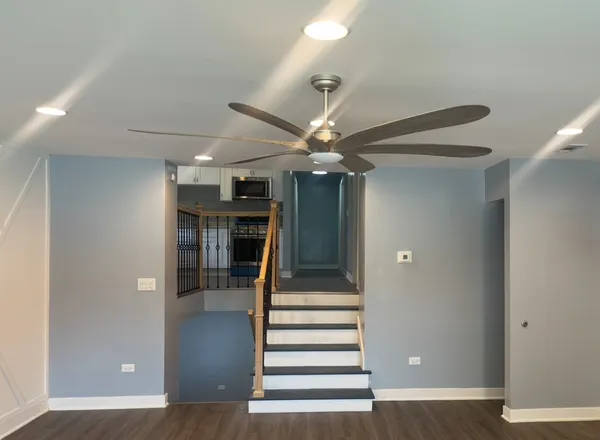 a view of a hallway with wooden floor and staircase