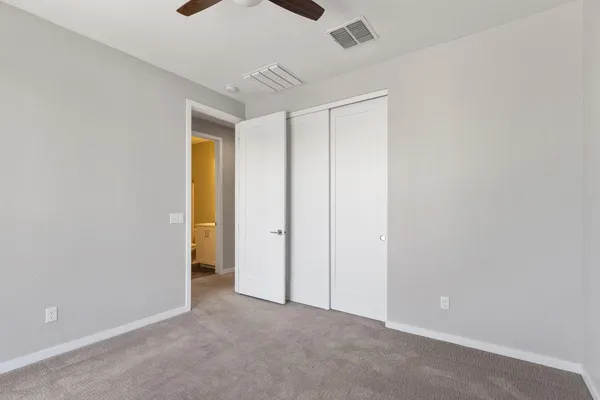 a view of a hallway with wooden floor and a bathroom