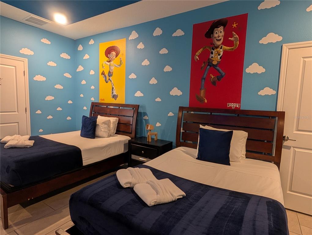 2800 Simile Street Kissimmee, FL 34746 - Photo 13 of 62 a bedroom with a bed and wooden floor