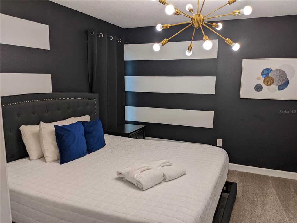 2800 Simile Street Kissimmee, FL 34746 - Photo 22 of 62 a bedroom with a bed and lamp with the walls