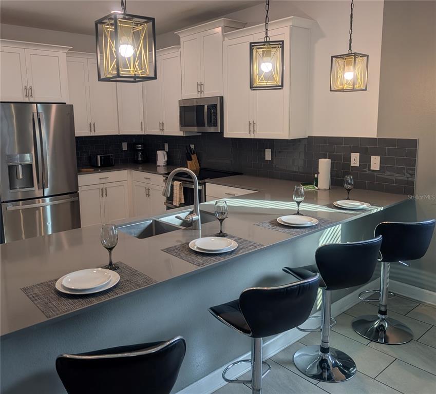 2800 Simile Street Kissimmee, FL 34746 - Photo 3 of 62 a kitchen with a dining table and chairs