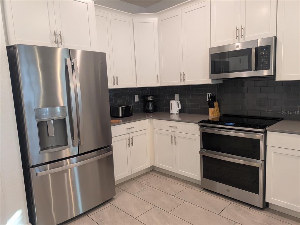 2800 Simile Street Kissimmee, FL 34746 - Photo 4 of 62 a kitchen with stainless steel appliances and cabinets