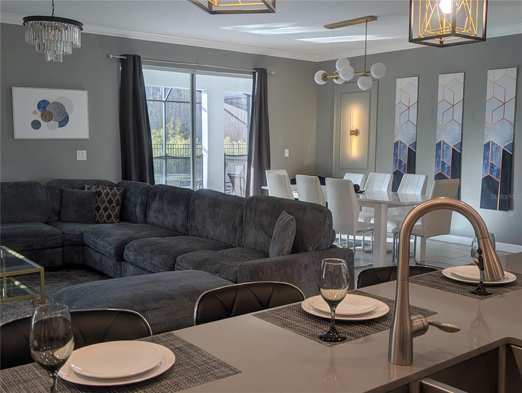 2800 Simile Street Kissimmee, FL 34746 - Photo 5 of 62 a living room with furniture a large window and a chandelier