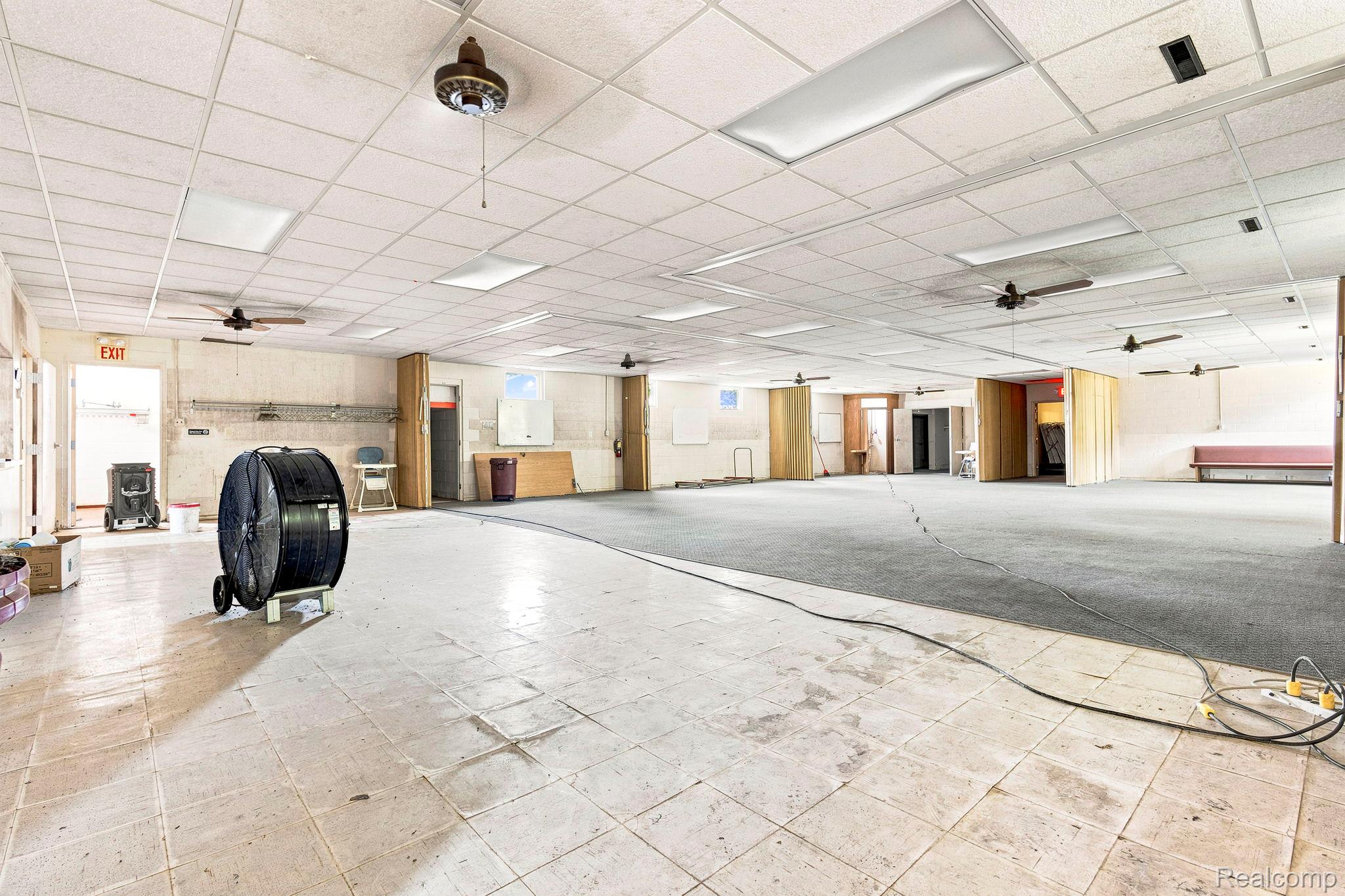 9735 Dolan Road Columbus, MI 48063 - Photo 55 of 63 Expansive open space featuring dropped acoustic ceiling tiles, multiple ceiling fans, and integrated fluorescent lighting panels