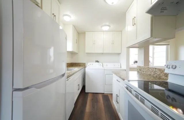 a large white kitchen with a large window