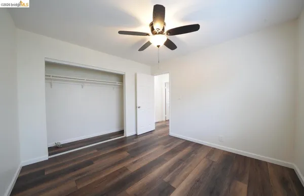 a view of room with hardwood floor and ceiling fan