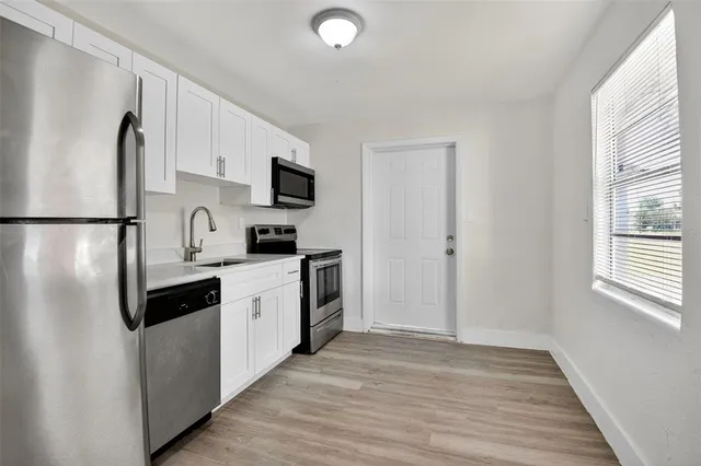 a kitchen with a refrigerator a stove top oven a sink and dishwasher