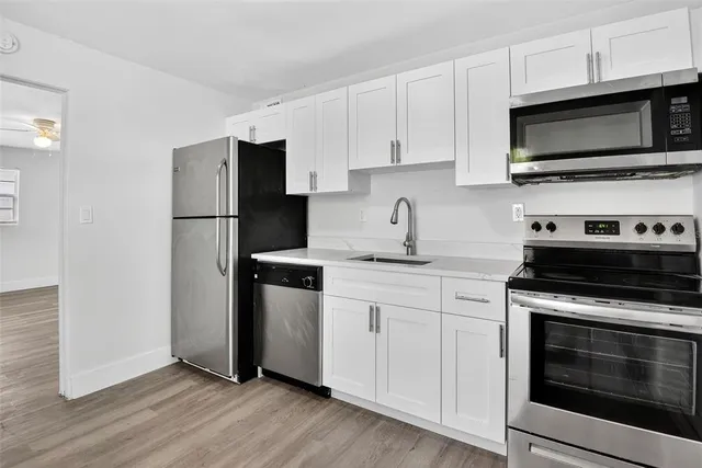 a kitchen with stainless steel appliances a stove a microwave sink and cabinets
