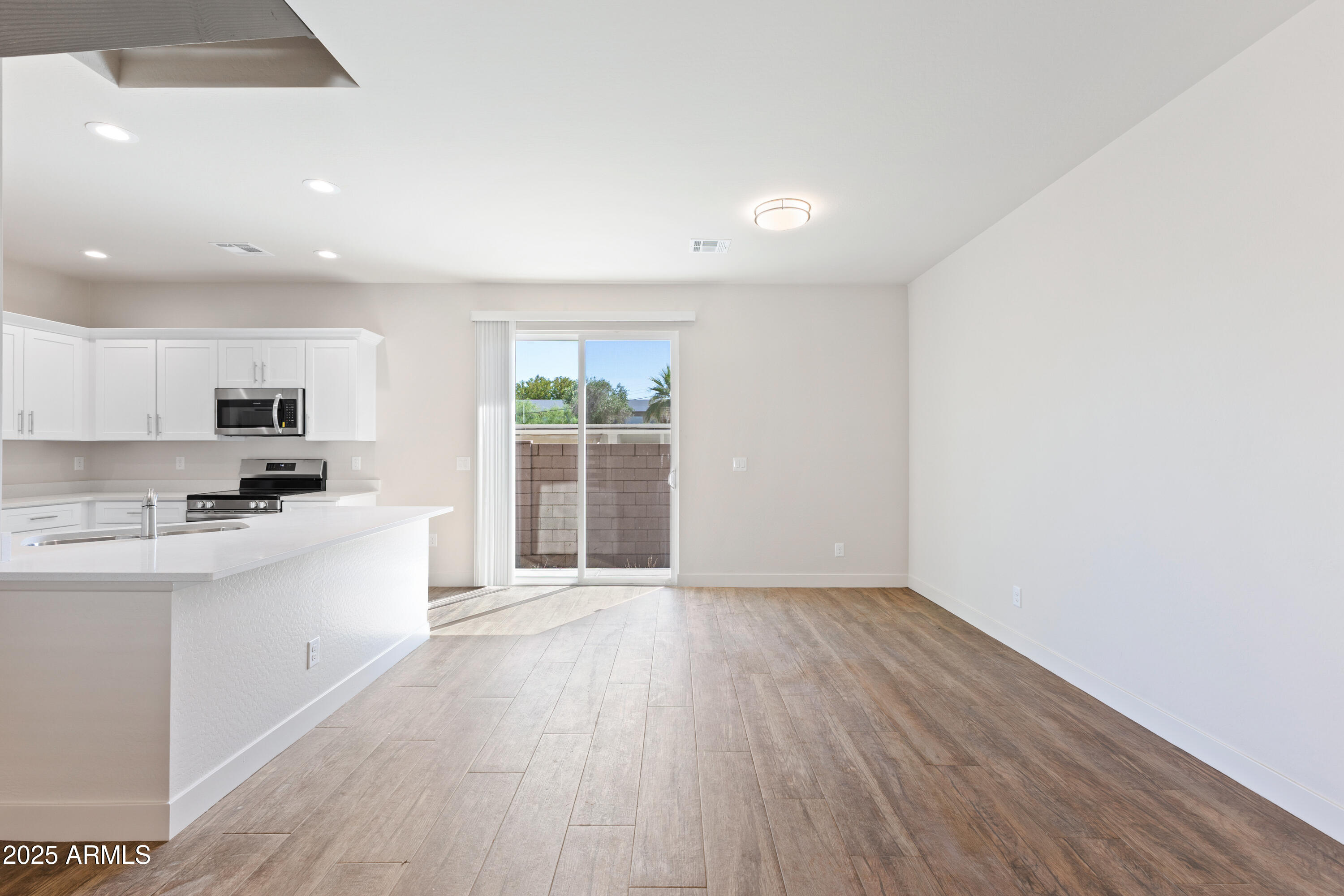 4307 North 13th Place Phoenix, AZ 85014 - Photo 10 of 35 a large white kitchen with wooden floors and white walls
