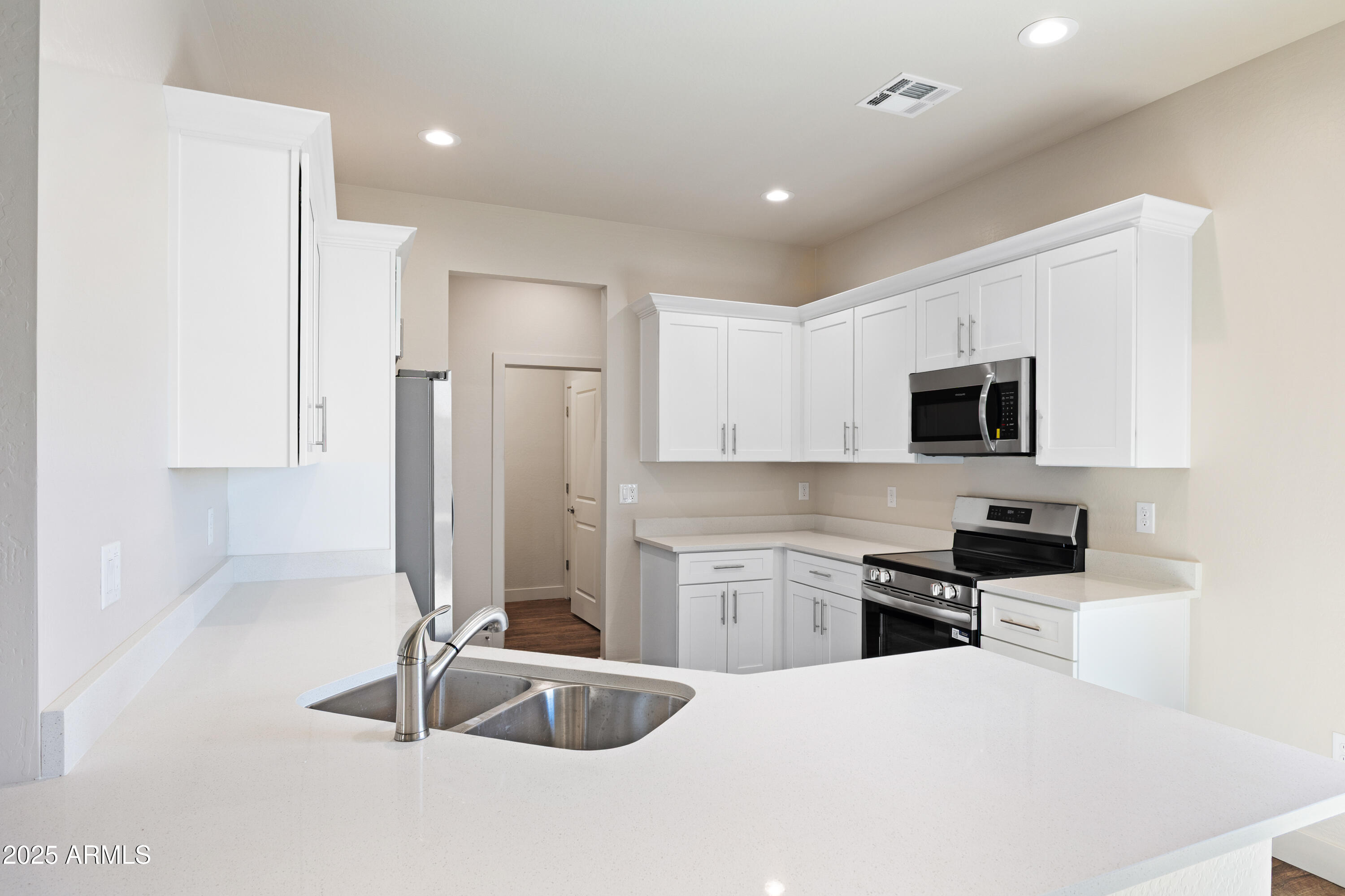 4307 North 13th Place Phoenix, AZ 85014 - Photo 13 of 35 a kitchen with stainless steel appliances kitchen island granite countertop a refrigerator a stove a sink and white cabinets with wooden floor