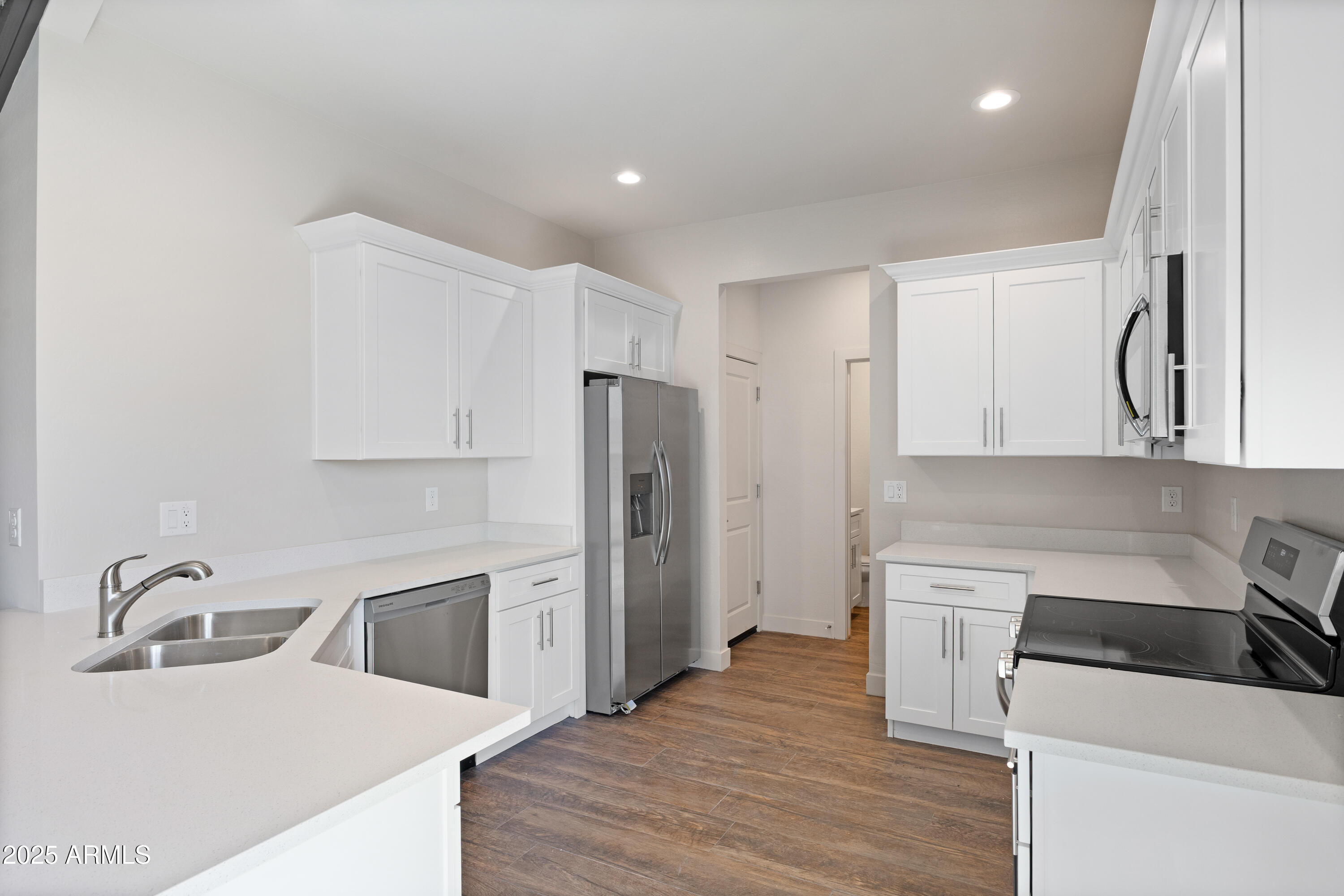 4307 North 13th Place Phoenix, AZ 85014 - Photo 14 of 35 a kitchen with a sink a refrigerator and a stove top oven with wooden floor