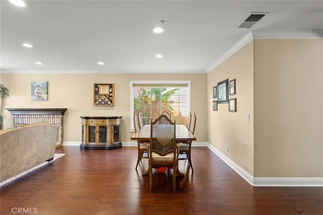 a view of a livingroom with furniture a fireplace wooden floor and a window