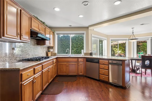 a large kitchen with stainless steel appliances granite countertop a stove and a sink