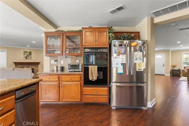 a kitchen with stainless steel appliances granite countertop a refrigerator and a stove top oven