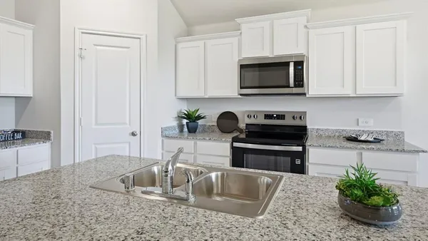 a kitchen with stainless steel appliances granite countertop a sink a stove and a microwave