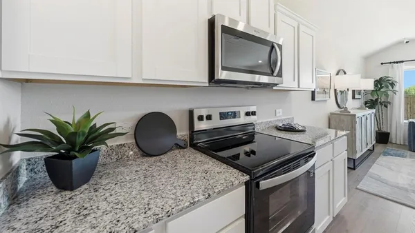 a kitchen with stainless steel appliances granite countertop a stove a microwave a sink and cabinets