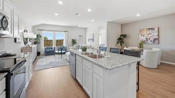 a kitchen with stainless steel appliances granite countertop sink stove top oven and cabinets