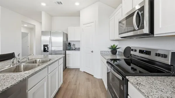 a kitchen with stainless steel appliances granite countertop a sink stove and cabinets