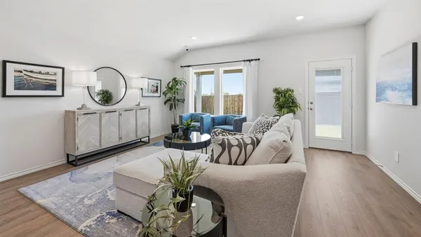 a living room with furniture a window and wooden floor