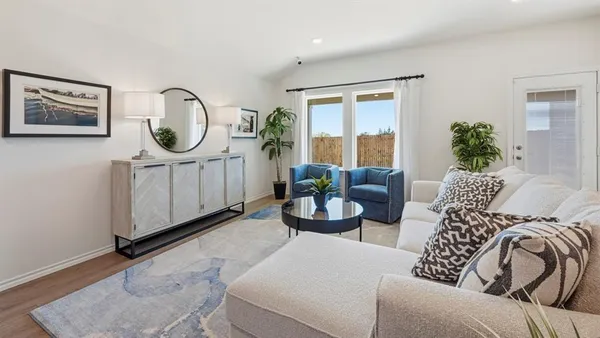 a living room with furniture a window and a potted plant