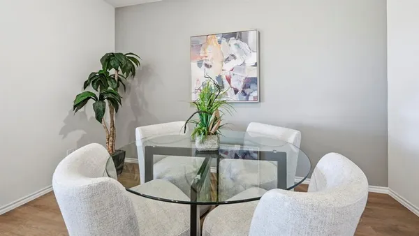 a dining room with furniture and a potted plant