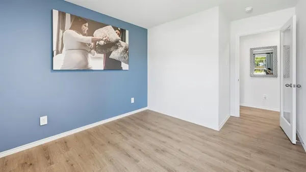 an empty room with wooden floor and wall painting