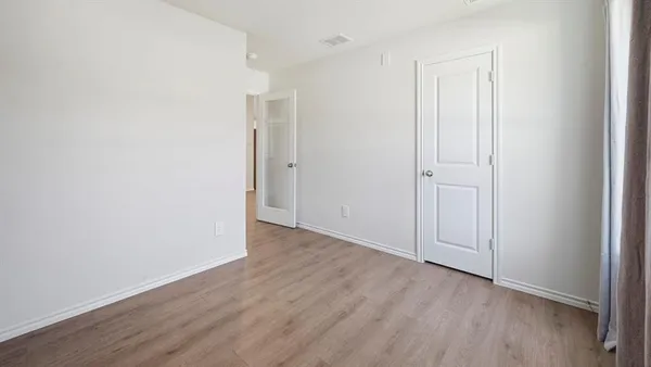 a view of an empty room with wooden floor