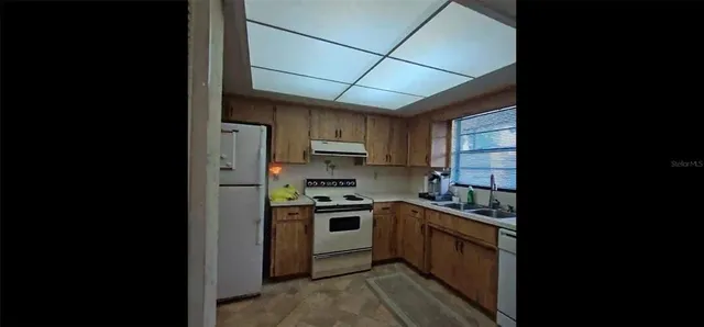 a kitchen with stainless steel appliances granite countertop a stove a sink dishwasher and a refrigerator