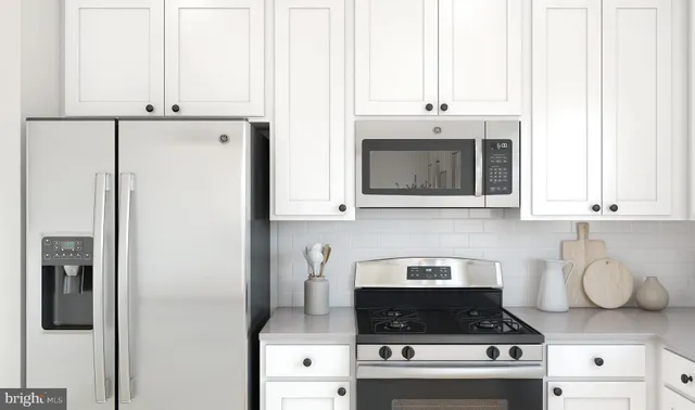 a kitchen with stainless steel appliances granite countertop a stove a refrigerator and a microwave