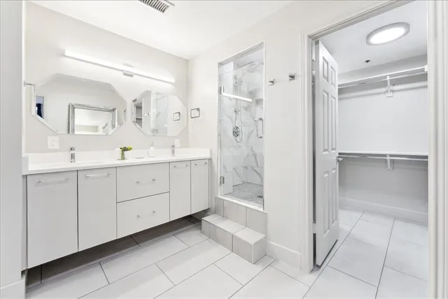 a spacious bathroom with a shower sink and a mirror