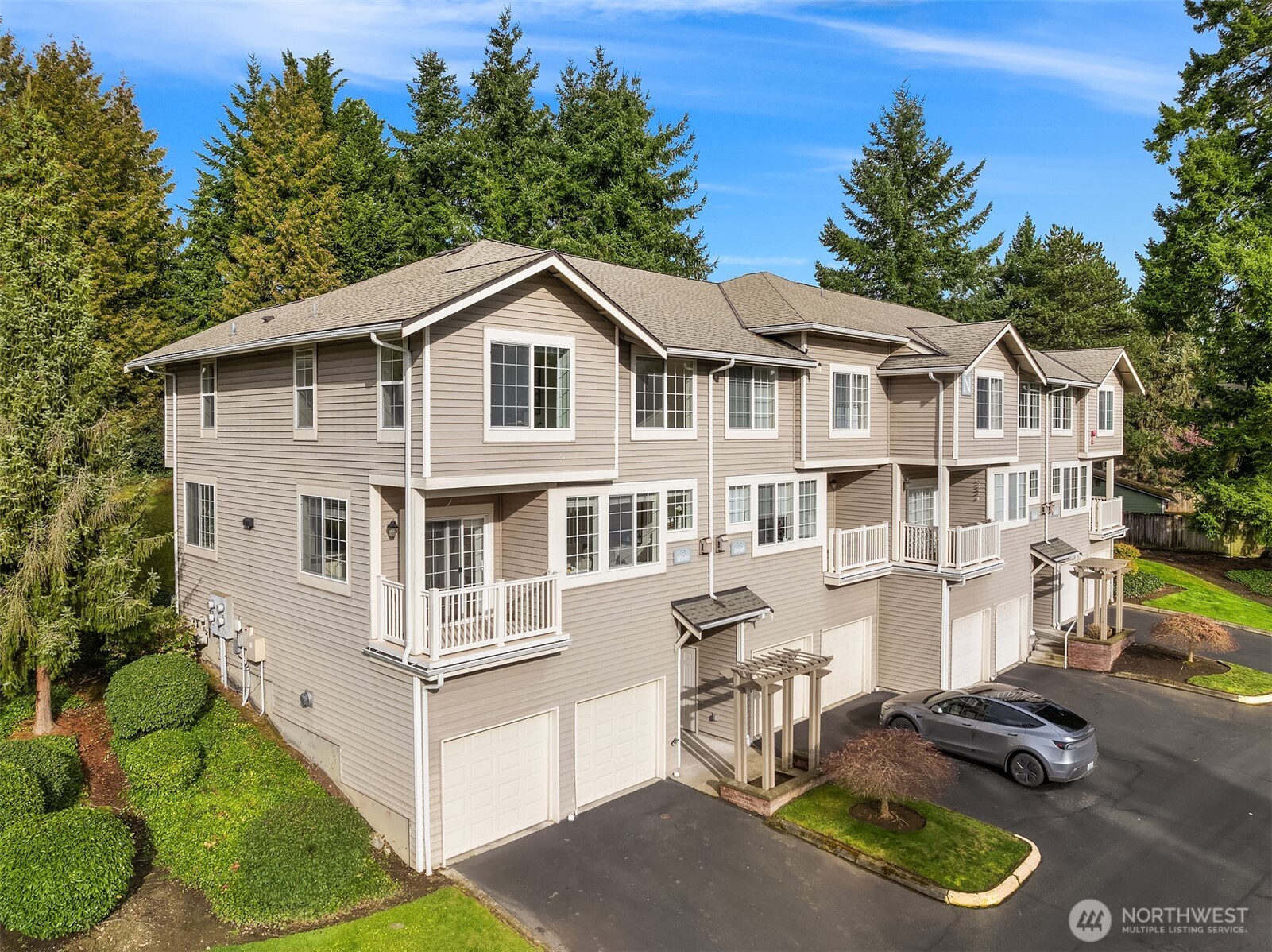 18646 Northeast 57th Way Redmond, WA 98052 - Photo 32 of 40 a white house with a large pool and lawn chairs under an umbrella