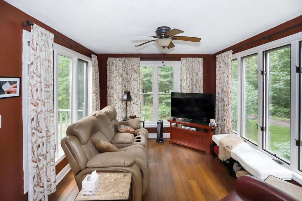 29 Lexington Drive, Unit 29 Atkinson, NH 03811 - Photo 13 of 31 a living room with furniture floor to ceiling window hardwood floor and a flat screen tv